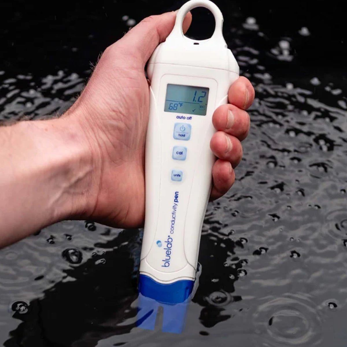 BlueLab Conductivity (EC) Pen being submerged in hydroponic solution, measuring conductivity and temperature.